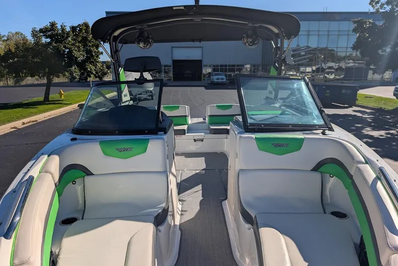 Slide: The Image of 2018 Chaparral Vortex 223 VRX boat interior with green accents, parked outdoors. - 10