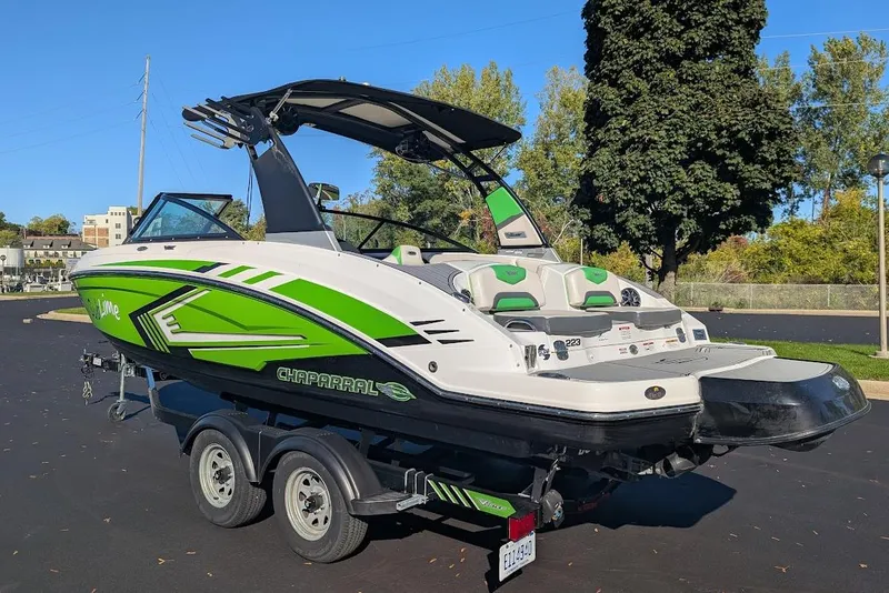 Slide: The Image of 2018 Chaparral Vortex 223 VRX boat with vibrant green accents on a trailer. - 6