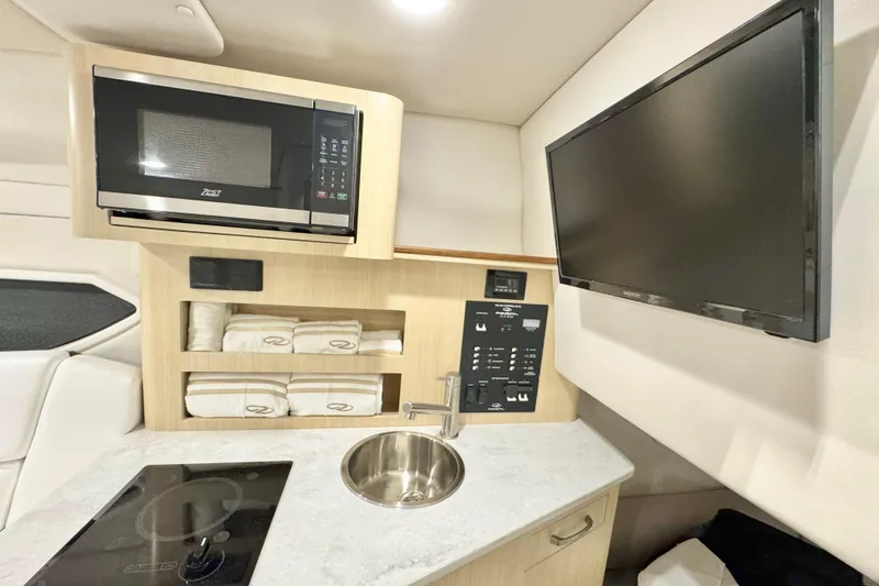 Slide: The Image of 2026 Regal 26 XO boat interior with microwave, TV, sink, and control panel. - 18