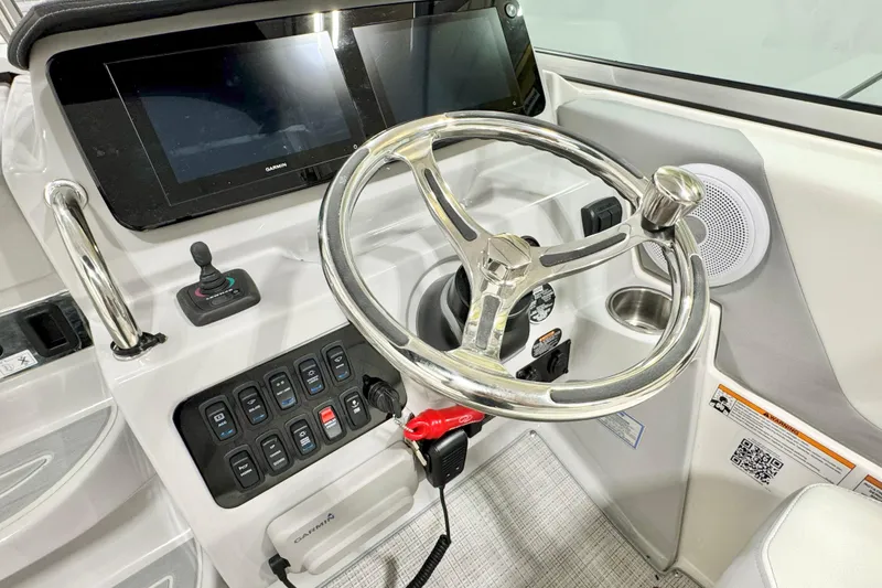 Slide: The Image of 2026 Regal 26 XO boat helm with steering wheel, control panel, and Garmin display. - 9