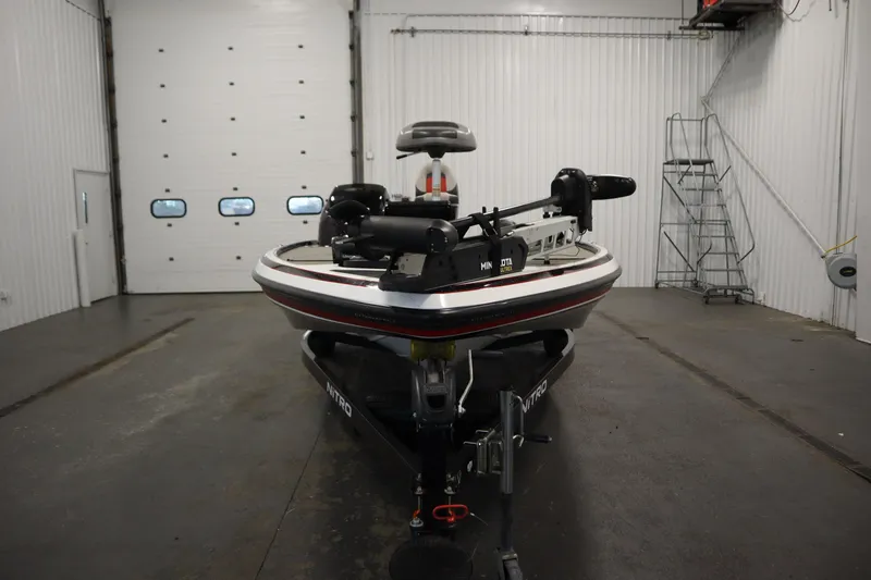 Slide: The Image of 2014 Nitro Z-7 boat in a garage, front view, with trolling motor attached. - 2