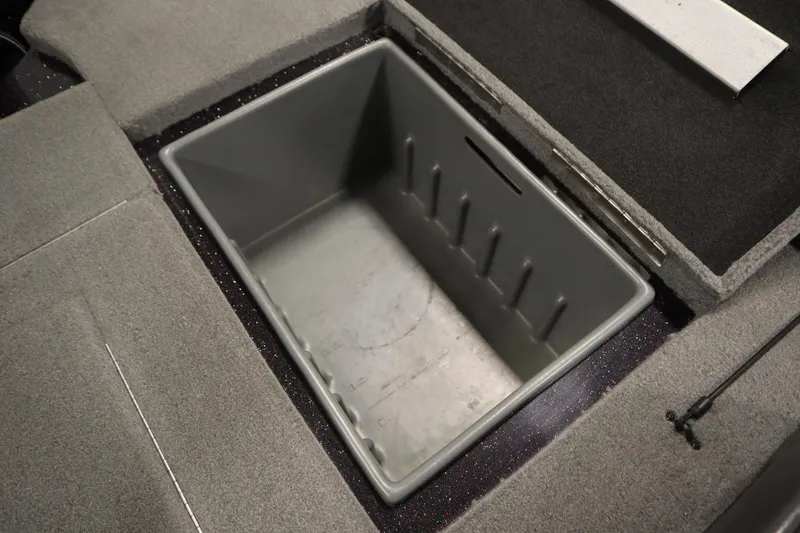 Slide: The Image of Open storage compartment in 2014 Nitro Z-7 boat, featuring gray interior and carpeted edges. - 37