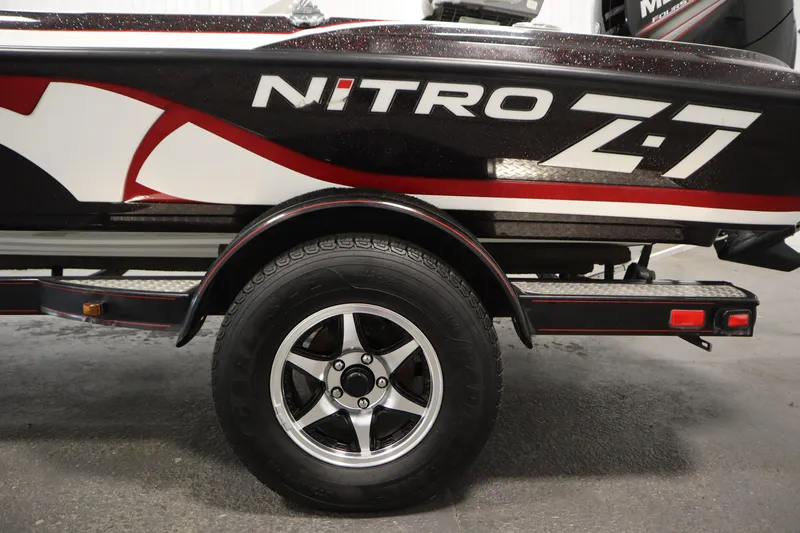 Slide: The Image of 2014 Nitro Z-7 boat trailer with black and red detailing, featuring a shiny wheel. - 49