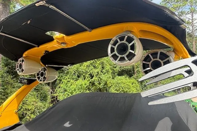 Slide: The Image of 2013 Tigé RZ4 boat with speakers and wakeboard rack, set against a forest backdrop. - 4