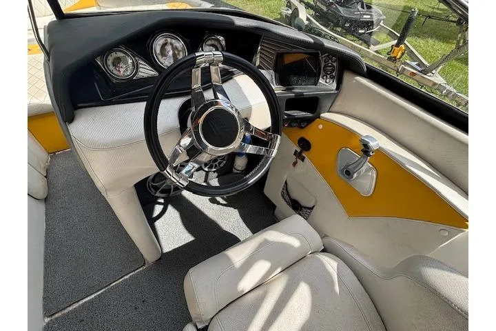 Slide: The Image of 2013 Tigé RZ4 boat interior with steering wheel and dashboard, featuring yellow accents. - 7