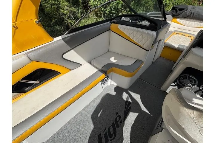 Slide: The Image of 2013 Tigé RZ4 boat interior with yellow and white seating, carpeted floor. - 9
