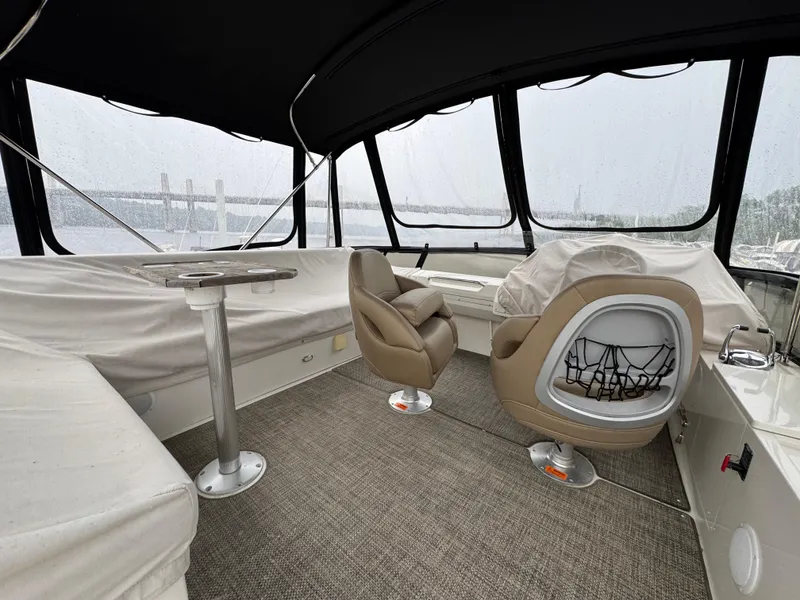 Slide: The Image of 2014 Carver C40 Command Bridge interior with covered seating and helm, featuring panoramic windows. - 15