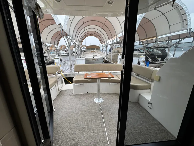 Slide: The Image of 2014 Carver C40 Command Bridge yacht interior with seating and table, docked under canopy. - 29