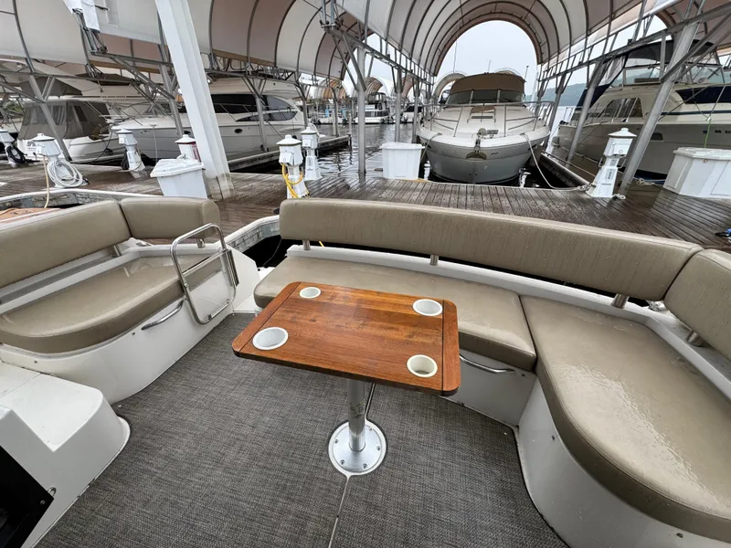 Slide: The Image of 2014 Carver C40 Command Bridge yacht interior with seating and wooden table at marina. - 30