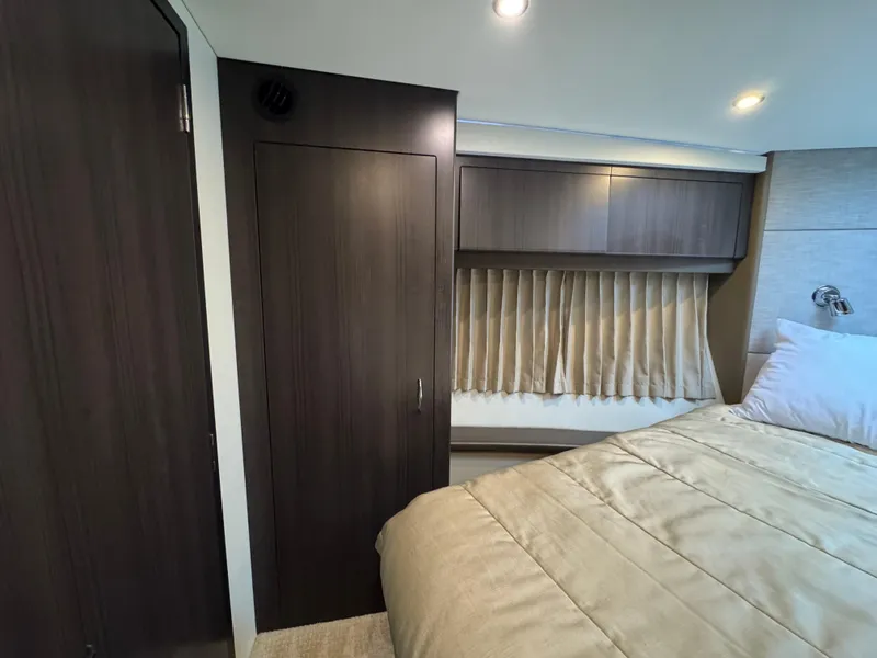 Slide: The Image of Interior of 2014 Carver C40 Command Bridge with bed, wooden cabinets, and curtains. - 45
