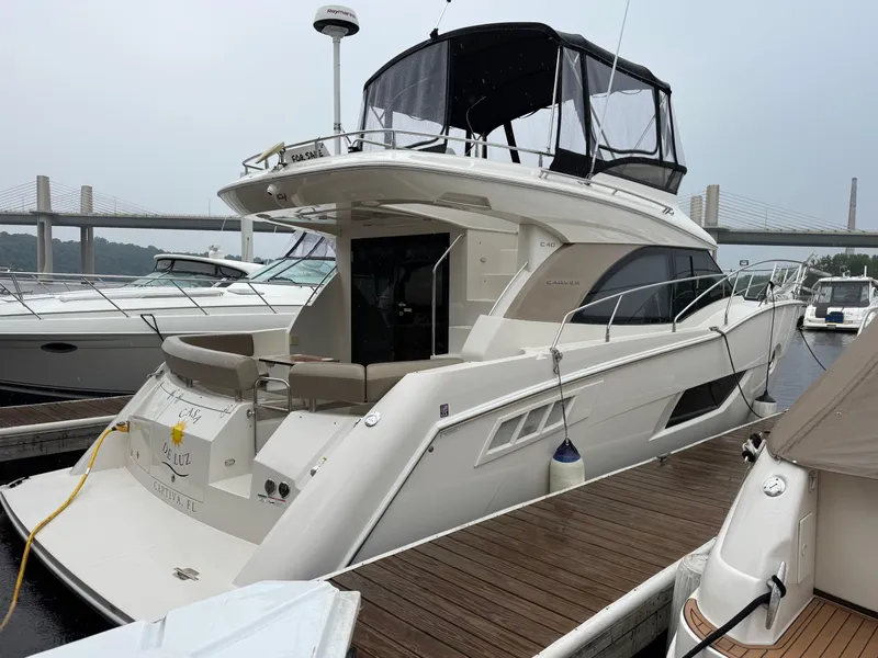 Slide: The Image of 2014 Carver C40 Command Bridge yacht docked at marina, featuring sleek design and spacious deck. - 6