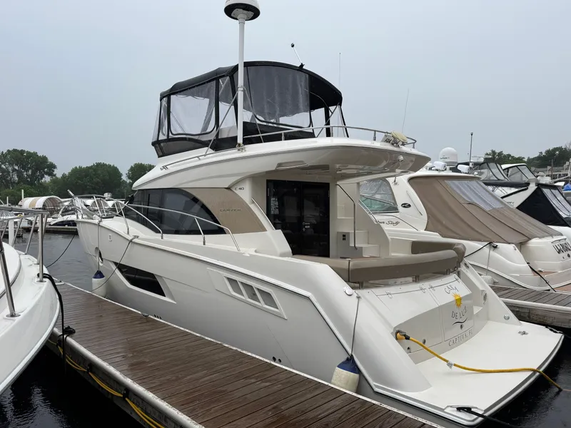 Slide: The Image of 2014 Carver C40 Command Bridge yacht docked at marina, featuring sleek design and spacious deck. - 8