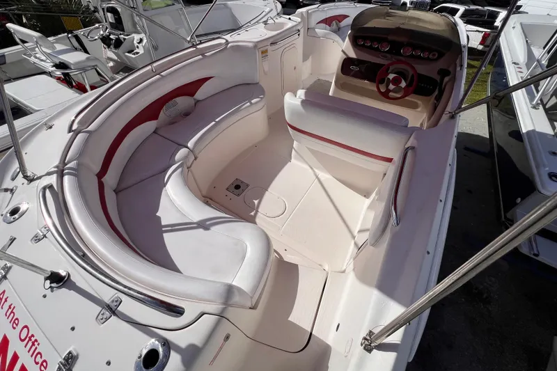Slide: The Image of 2002 Chaparral 232 Sunesta boat interior with white and red seating, steering wheel, and dashboard. - 10