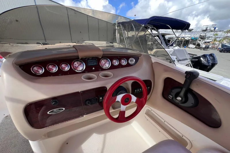 Slide: The Image of 2002 Chaparral 232 Sunesta boat dashboard with red steering wheel and gauges. - 17