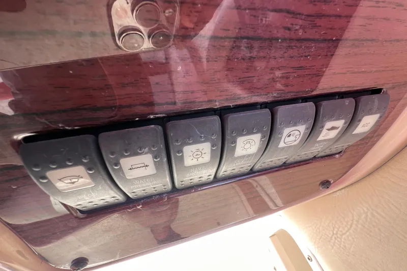 Slide: The Image of Control panel switches on a 2002 Chaparral 232 Sunesta boat dashboard. - 20