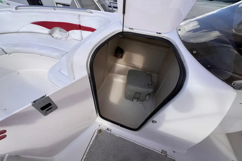 Slide: The Image of 2002 Chaparral 232 Sunesta boat interior with open storage compartment and seating area. - 24