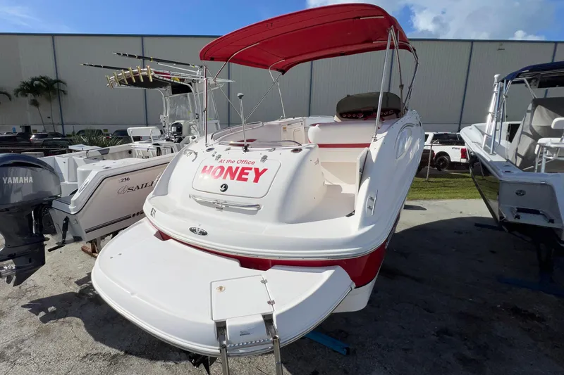 Slide: The Image of 2002 Chaparral 232 Sunesta boat with red canopy, docked outdoors. - 5