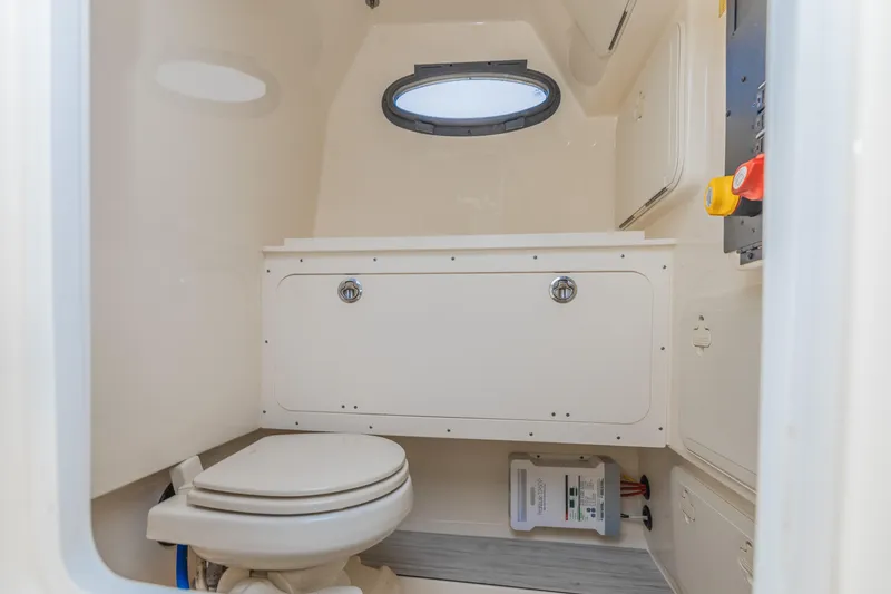Slide: The Image of 2021 Scout 277LXF boat interior bathroom with toilet and storage. - 19