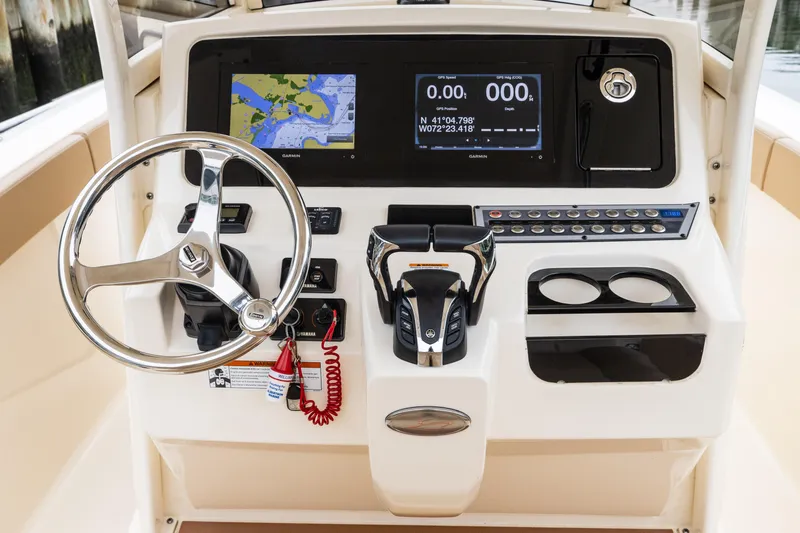 Slide: The Image of 2021 Scout 277LXF boat dashboard with steering wheel, navigation screens, and control panel. - 3