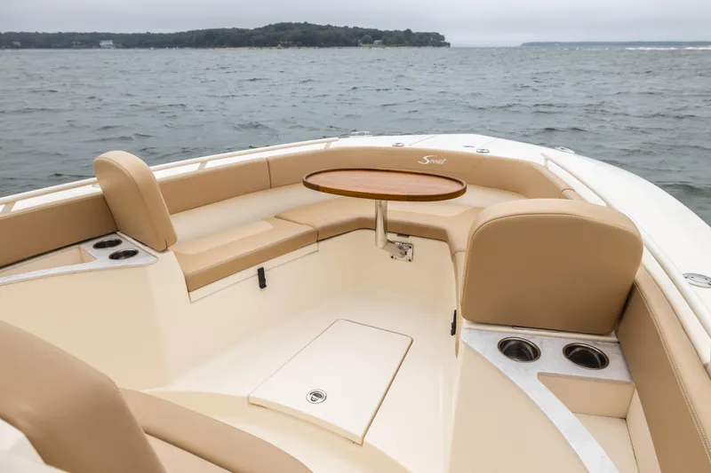 Slide: The Image of 2021 Scout 277LXF boat with beige seating and a round table on the water. - 4