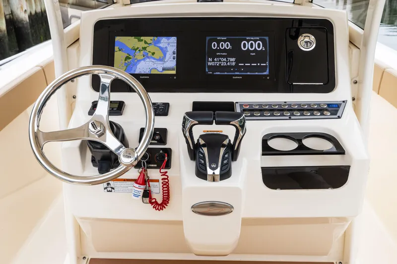 Slide: The Image of 2021 Scout 277 LXF boat dashboard with steering wheel and navigation display. - 6