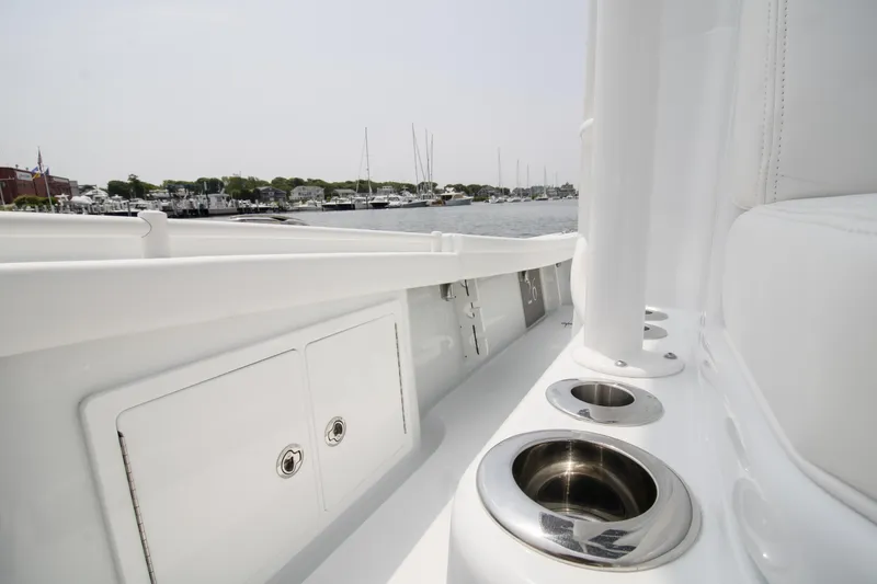Slide: The Image of 2025 Yellowfin 26 Hybrid boat interior with cup holders, docked at marina. - 19