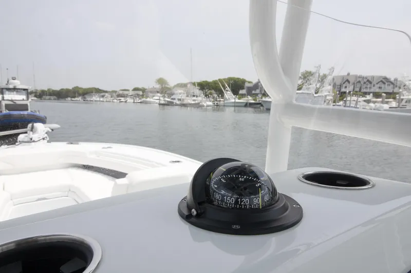 Slide: The Image of 2025 Yellowfin 26 Hybrid boat with compass, docked in a marina. - 7