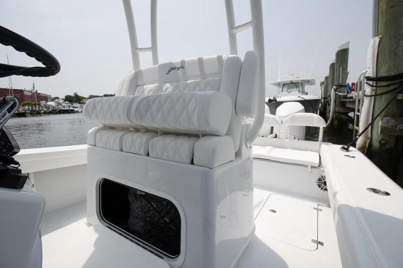 Slide: The Image of 2025 Yellowfin 26 Hybrid boat interior with white cushioned seating and storage compartment. - 9