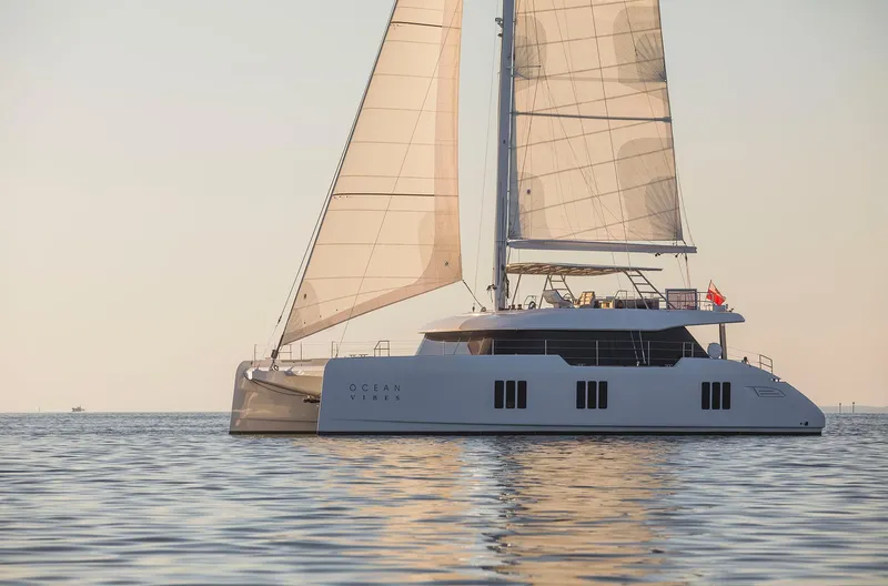 The Image of 2026 Sunreef 70 yacht sailing on calm waters at sunset. - 1