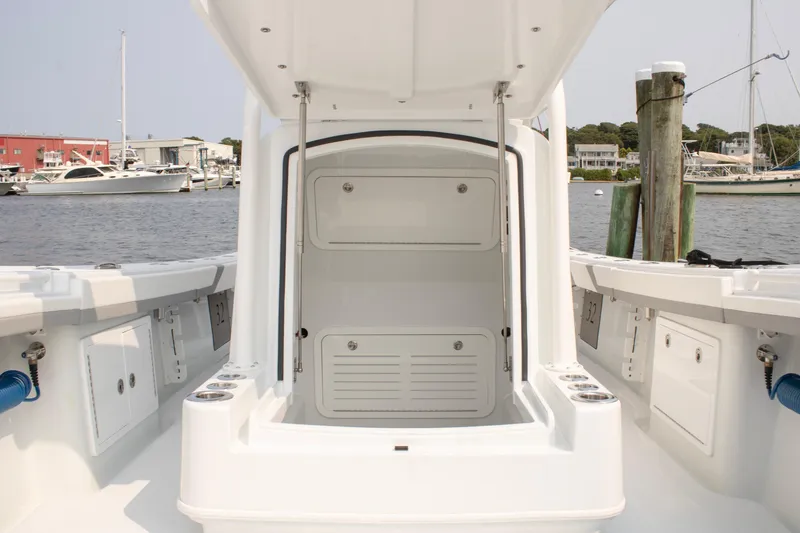 Slide: The Image of 2025 Yellowfin 32 Offshore boat interior, featuring storage compartments and sleek design at a marina. - 13