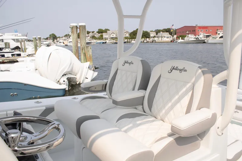 Slide: The Image of 2025 Yellowfin 32 Offshore boat interior with luxurious seating at a marina. - 16