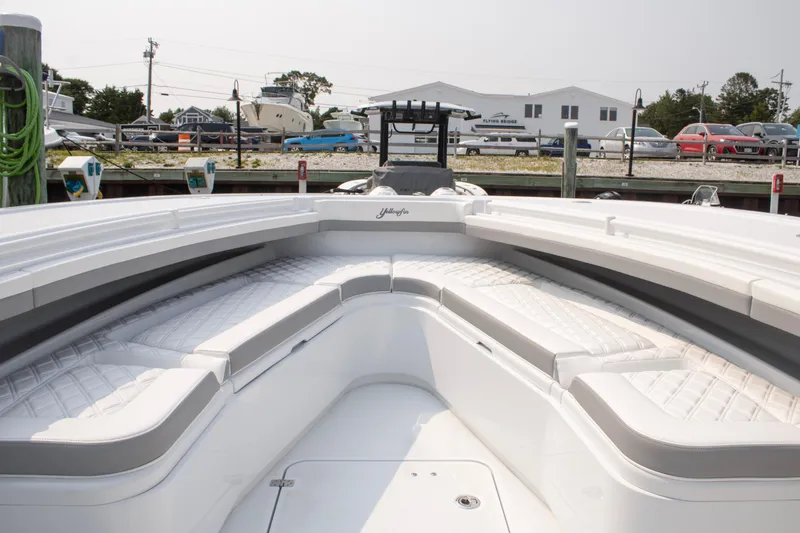 Slide: The Image of 2025 Yellowfin 32 Offshore boat interior with cushioned seating at dock. - 7