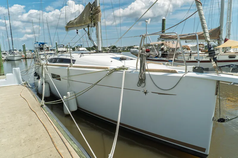 Slide: The Image of 2018 Jeanneau Sun Odyssey 349 sailboat docked at marina under blue sky. - 6