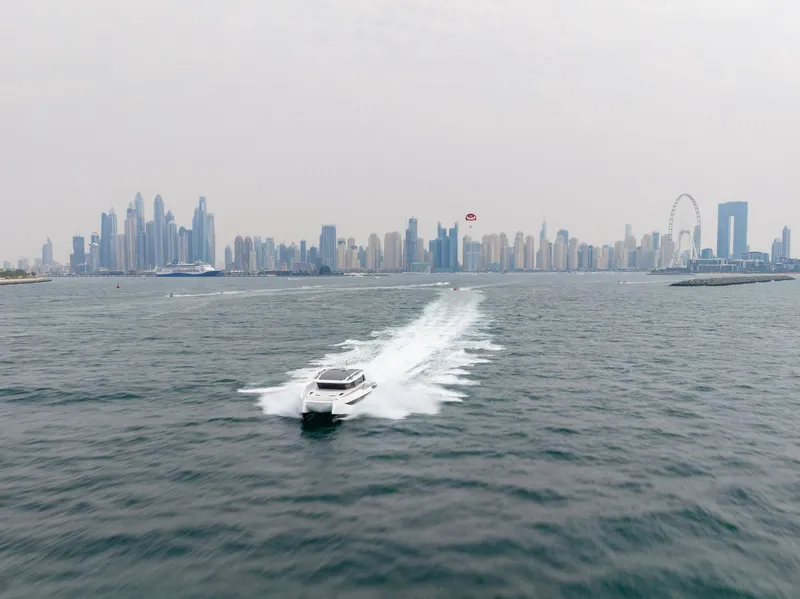 Slide: The Image of Luxury Sunreef 55 Ultima yacht cruising near Dubai skyline, 2026 model. - 16