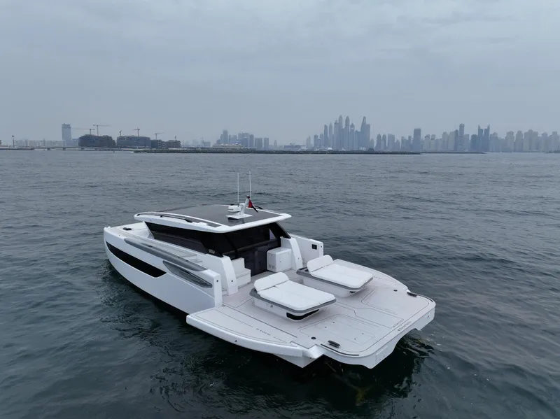 Slide: The Image of 2026 Sunreef 55 Ultima yacht on calm waters with city skyline in background. - 2