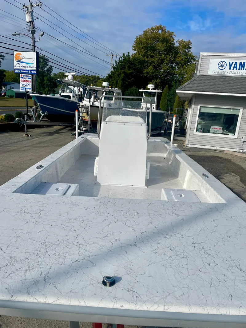 Slide: The Image of 2025 Coastal Skiff 212 boat on trailer at Yamaha Suzuki dealership. - 2