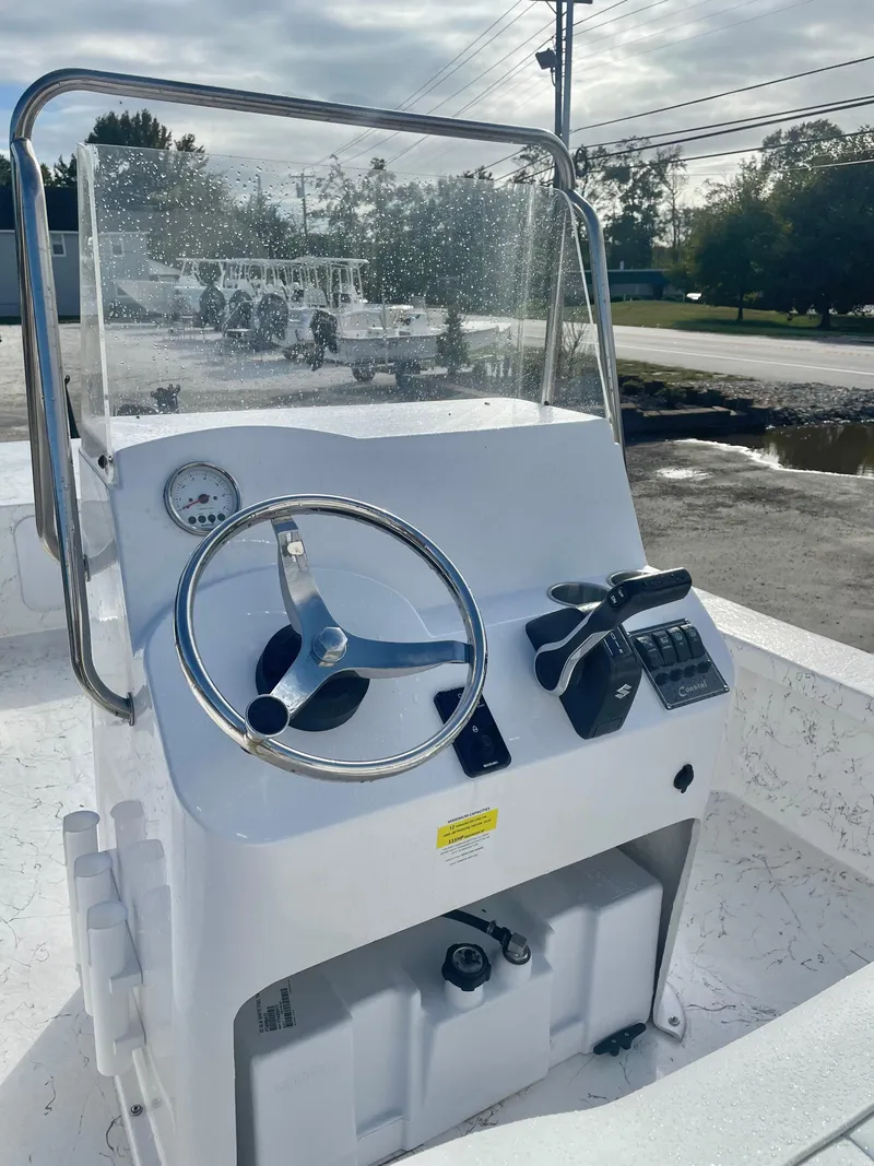 Slide: The Image of 2025 Coastal Skiff 212 boat interior with white seating and steering wheel. - 4