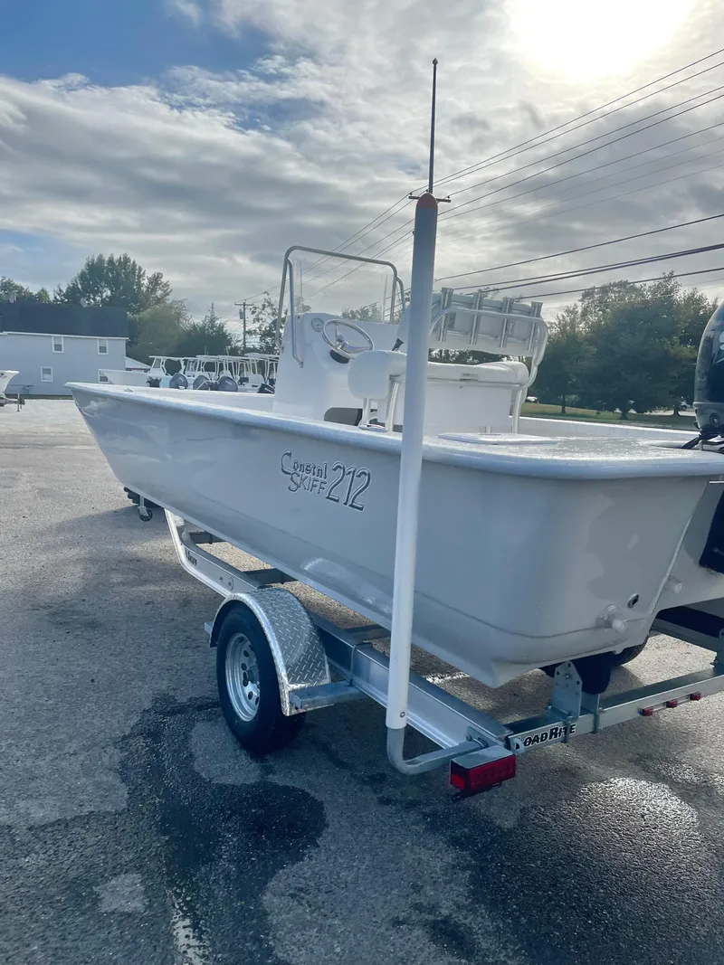 Slide: The Image of 2025 Coastal Skiff 212 boat on trailer under cloudy sky. - 7