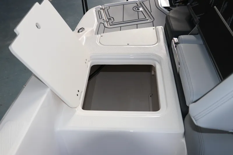 Slide: The Image of 2026 Chaparral 21 SSi OB boat storage compartment with open hatch, showcasing interior space. - 12