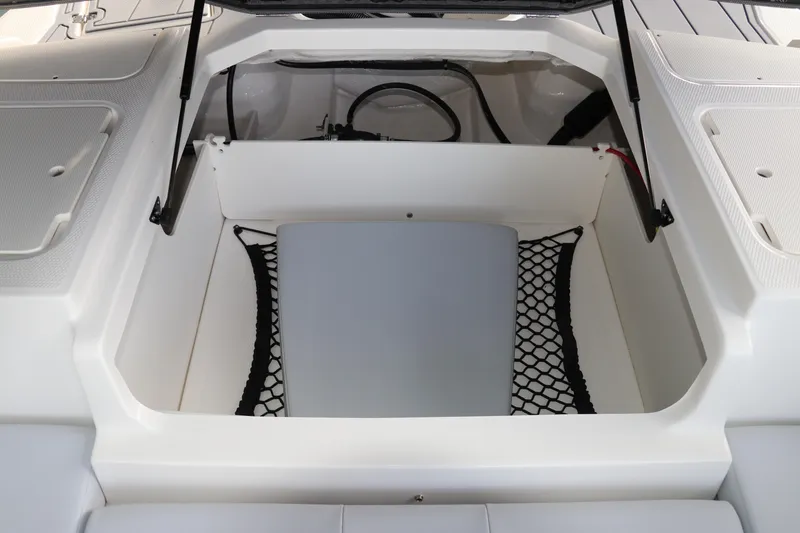 Slide: The Image of 2026 Chaparral 21 SSi OB boat storage compartment with netting and hydraulic lift. - 17