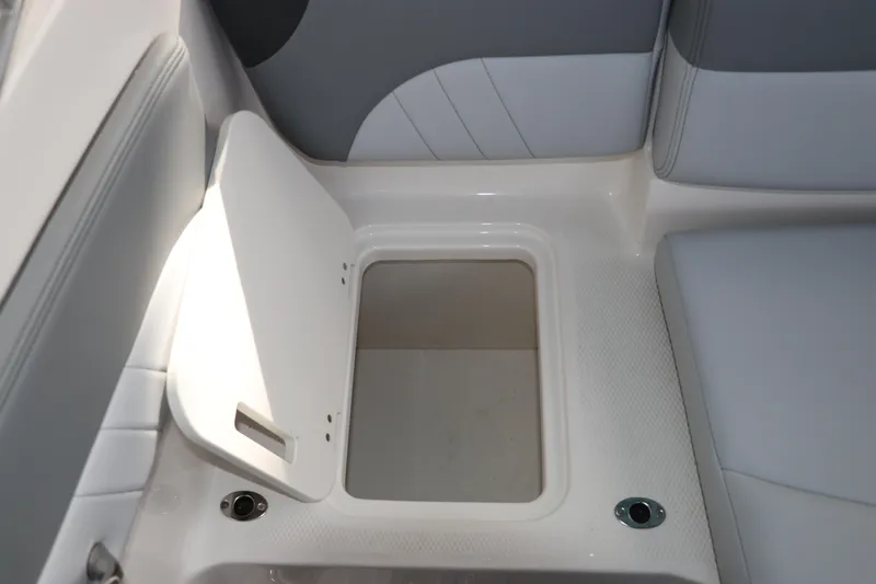 Slide: The Image of 2026 Chaparral 21 SSi OB boat storage compartment with open hatch, showcasing interior space. - 21
