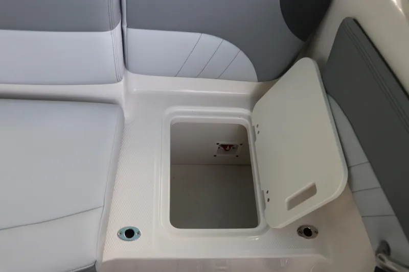 Slide: The Image of 2026 Chaparral 21 SSi OB boat storage compartment with open lid, showcasing interior space. - 22