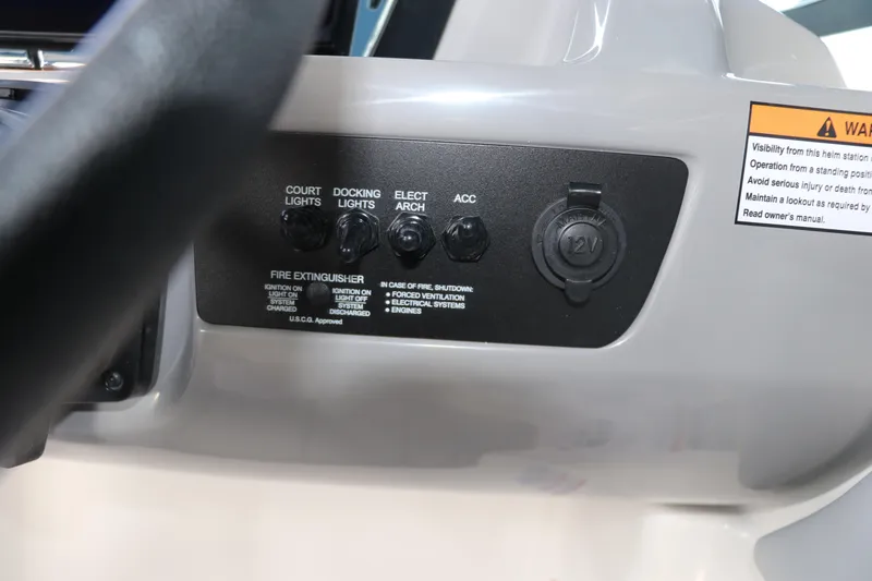 Slide: The Image of Control panel of 2026 Chaparral 21 SSi OB boat with switches and warning label. - 31