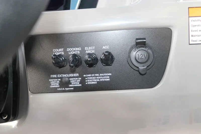 Slide: The Image of Control panel of 2026 Chaparral 21 SSi OB boat with switches and 12V outlet. - 32