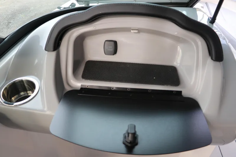 Slide: The Image of 2026 Chaparral 21 SSi OB boat dashboard with storage compartment and cup holder. - 41