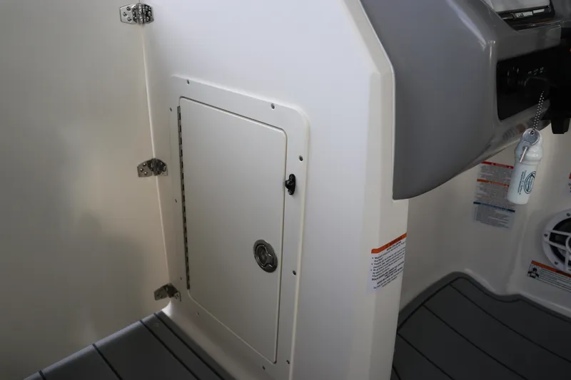 Slide: The Image of 2026 Chaparral 21 SSi OB interior storage compartment with secure latch and modern design. - 46