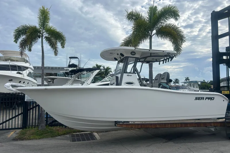 The Image of 2026 Sea Pro 262 DLX boat displayed outdoors with palm trees in the background. - 0