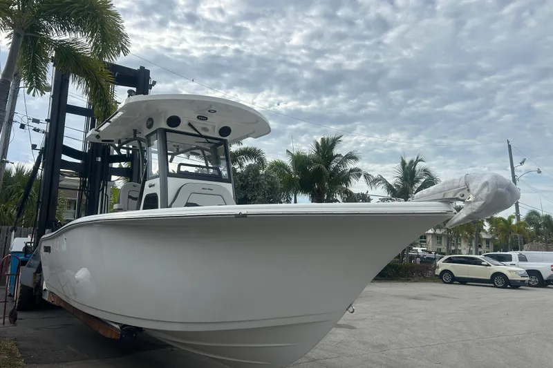Slide: The Image of 2026 Sea Pro 262 DLX boat on a lift, surrounded by palm trees. - 2