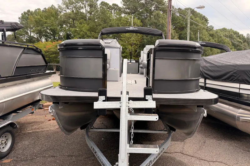 Slide: The Image of 2026 Veranda VR 235 RC pontoon boat on trailer, surrounded by trees and other boats. - 2