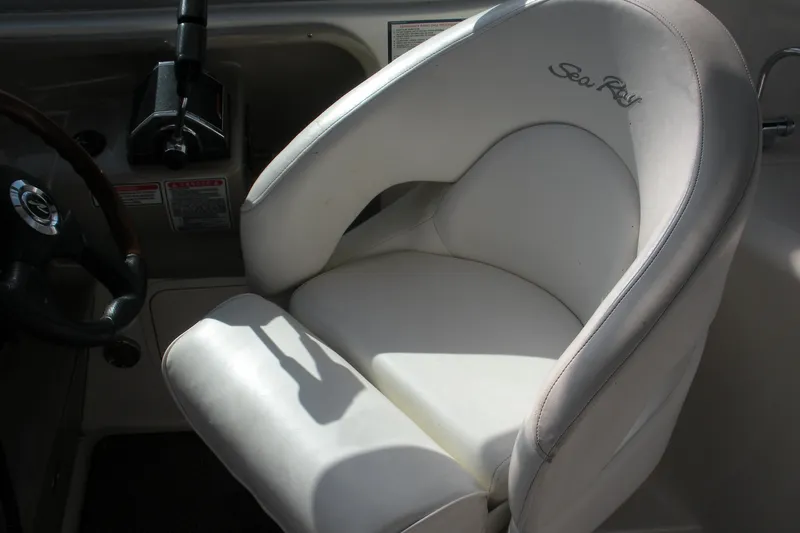 Slide: The Image of Captain's seat on 2005 Sea Ray 280 Sundancer boat, featuring white upholstery and control panel. - 14